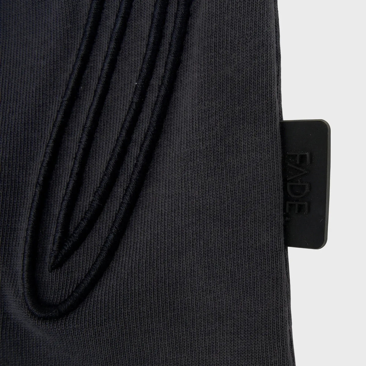 Close-up of a dark grey FT070 Signature Relaxed Fit T-Shirt, showing the fabric texture and a black FADE tag on the side.
