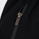 Close-up of black FJ033 Iconic Badge Shorts, showcasing the detailed silver zipper with the 'FADE.' logo on the pull tab.